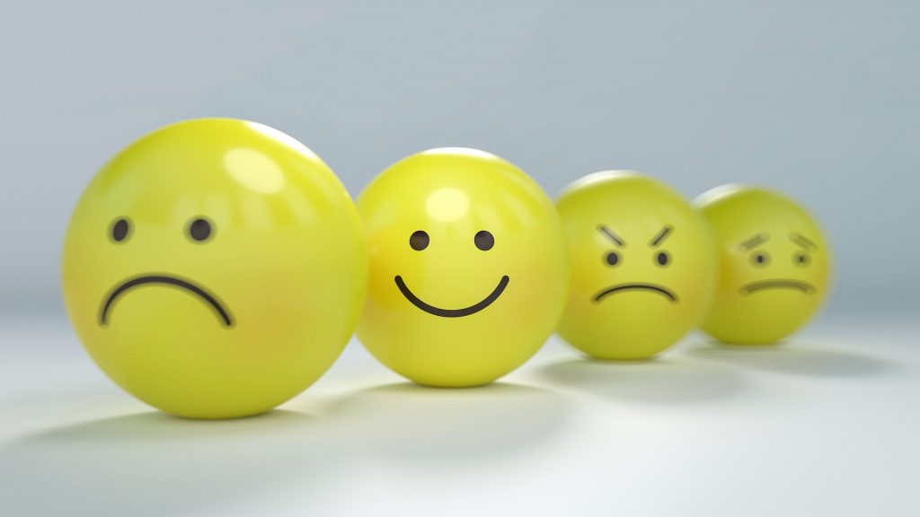 Set of four yellow smiley balls showing different emotions: sad, happy, angry, and anxious/concernedFace icons without text.