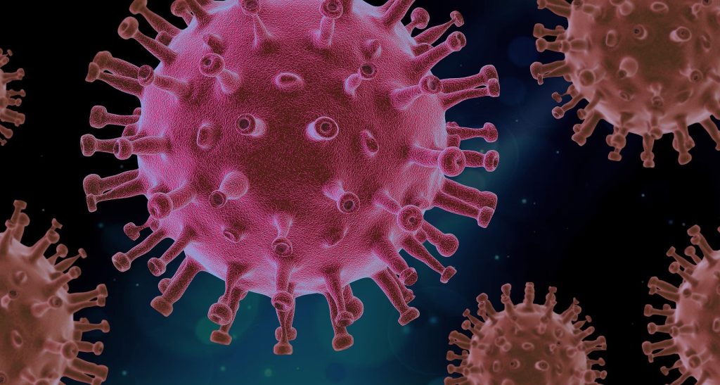 Pinkish virus particle with spike proteins against a dark background, illustrating a microscopic pathogen