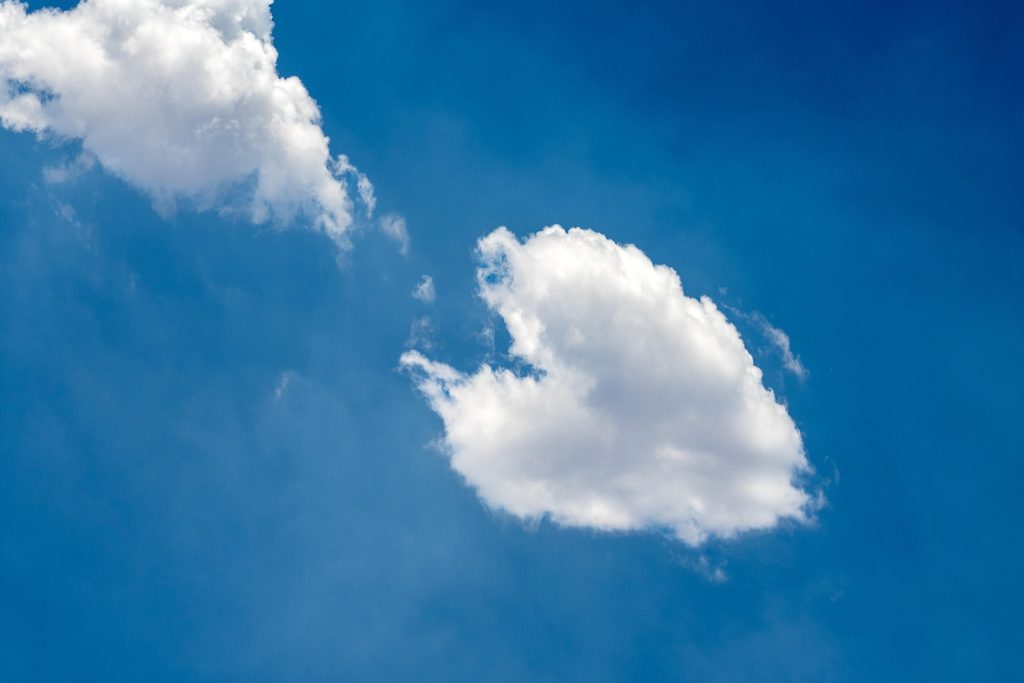 Clear blue sky with a few fluffy white clouds.
